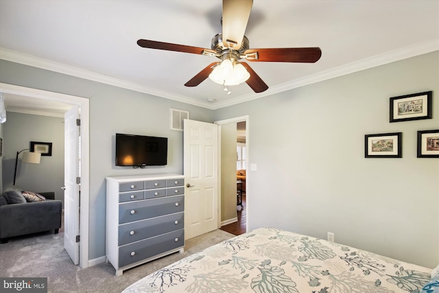 bedroom featuring ceiling fan, crown molding, and carpet floors