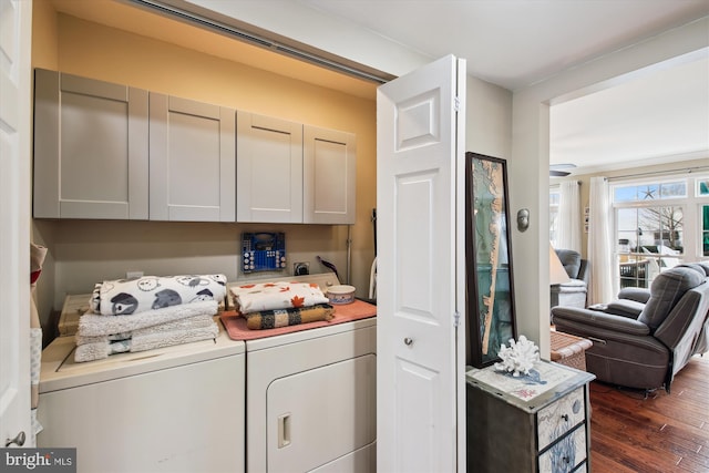 clothes washing area featuring cabinets, dark hardwood / wood-style flooring, and washing machine and dryer