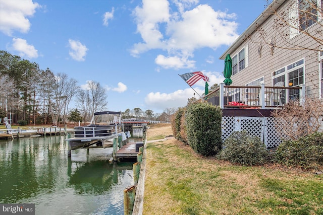 view of dock with a water view and a yard