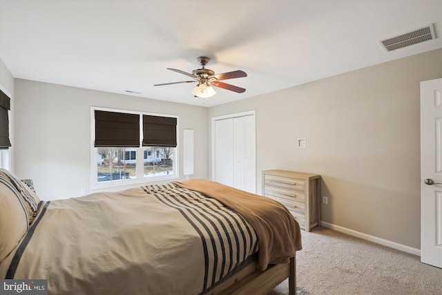 bedroom featuring a closet, ceiling fan, and light carpet