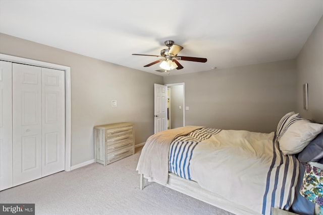 bedroom featuring ceiling fan, light colored carpet, and a closet