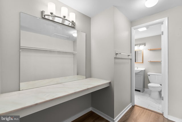 bathroom featuring vanity, wood-type flooring, and toilet