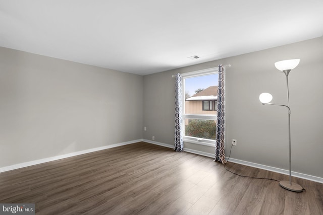 unfurnished room with dark hardwood / wood-style flooring