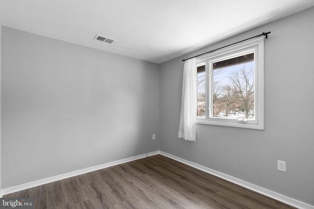 spare room with dark wood-type flooring