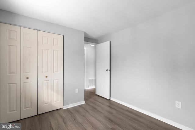 unfurnished bedroom with hardwood / wood-style flooring and a closet