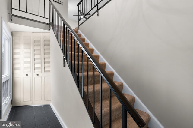 stairway featuring tile patterned floors and a high ceiling