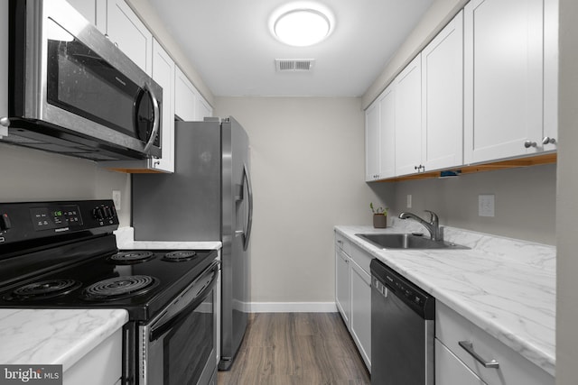 kitchen featuring dark wood-type flooring, sink, stainless steel appliances, light stone countertops, and white cabinets