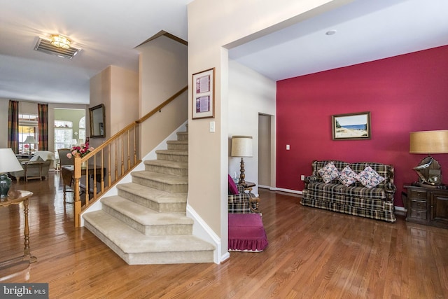 stairs featuring hardwood / wood-style floors