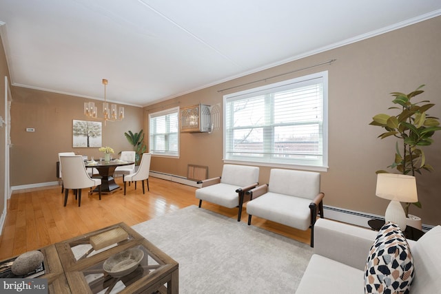 living room featuring a notable chandelier, baseboard heating, crown molding, and light hardwood / wood-style flooring