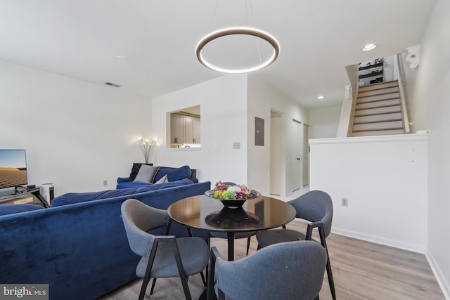 dining area featuring electric panel and light hardwood / wood-style flooring