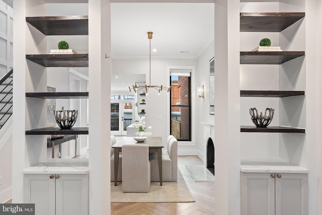 dining space featuring crown molding, a chandelier, and light parquet floors