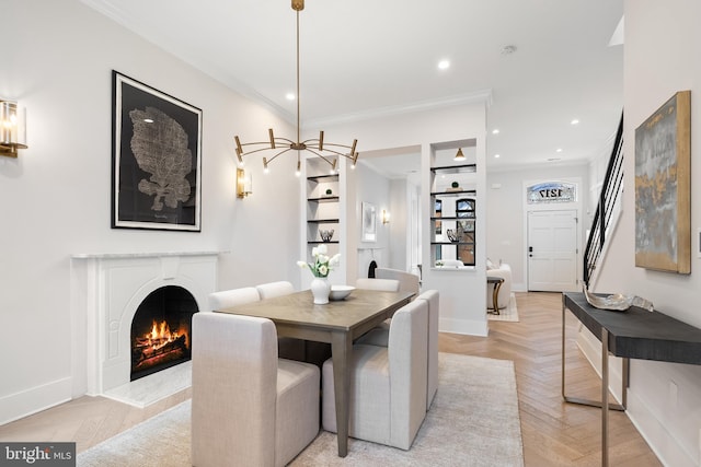 dining area featuring light parquet floors, crown molding, and a high end fireplace