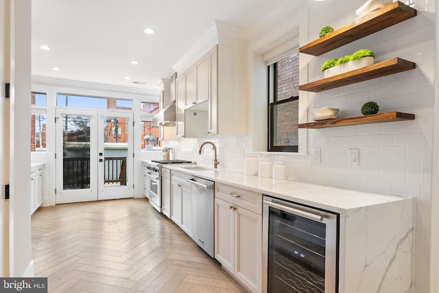 kitchen featuring sink, light stone countertops, white cabinets, beverage cooler, and light parquet flooring