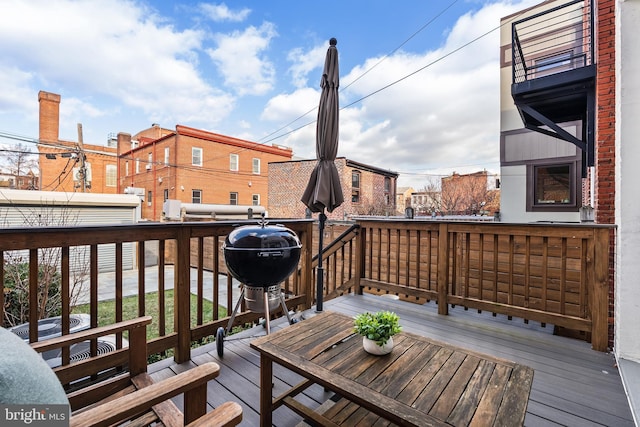 wooden deck with area for grilling and a fireplace