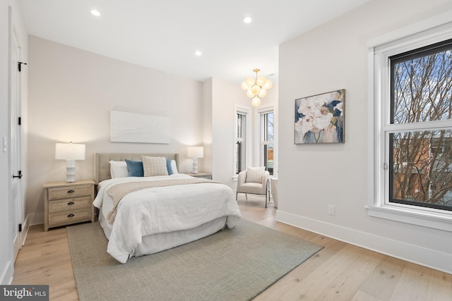 bedroom featuring light hardwood / wood-style floors and a chandelier