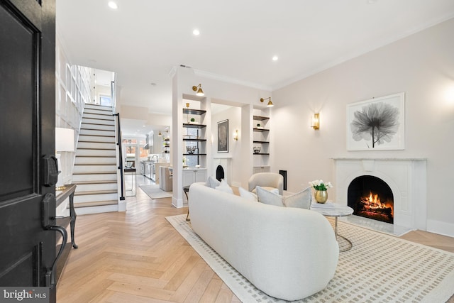 living room featuring light parquet flooring, built in features, and crown molding