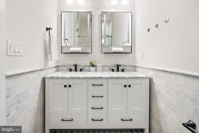 bathroom featuring vanity and tile walls