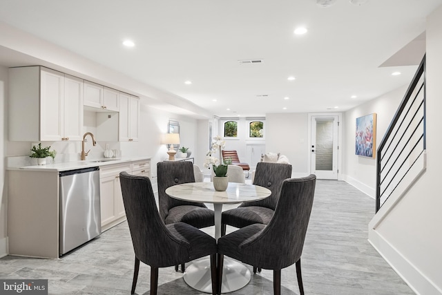 dining room with sink and light hardwood / wood-style flooring