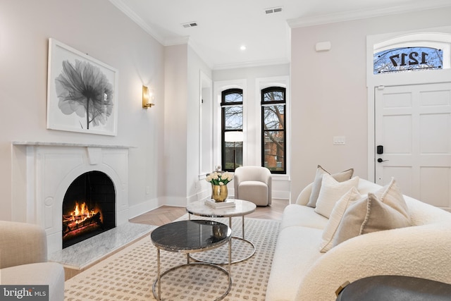 living room featuring ornamental molding, a premium fireplace, and light hardwood / wood-style flooring