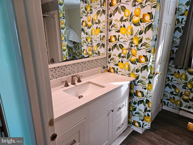 bathroom featuring vanity, hardwood / wood-style floors, and backsplash