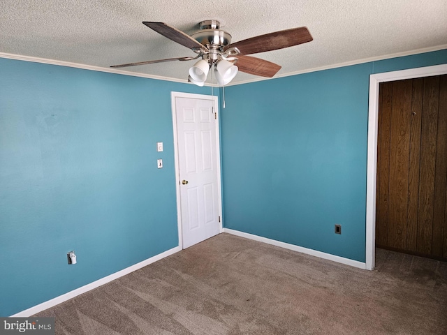 carpeted empty room with ceiling fan, a textured ceiling, and ornamental molding