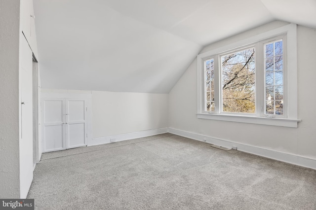 bonus room featuring light colored carpet and vaulted ceiling