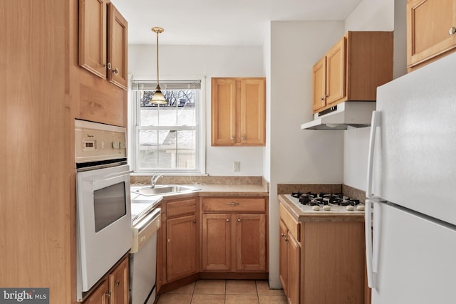 kitchen featuring sink, light tile patterned floors, decorative light fixtures, and white appliances