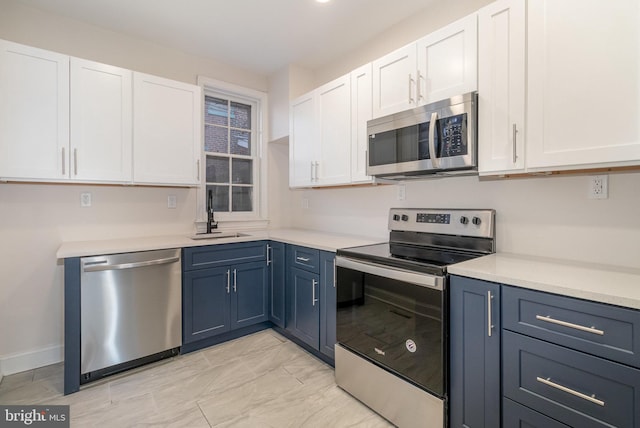 kitchen with white cabinetry, sink, blue cabinets, and appliances with stainless steel finishes