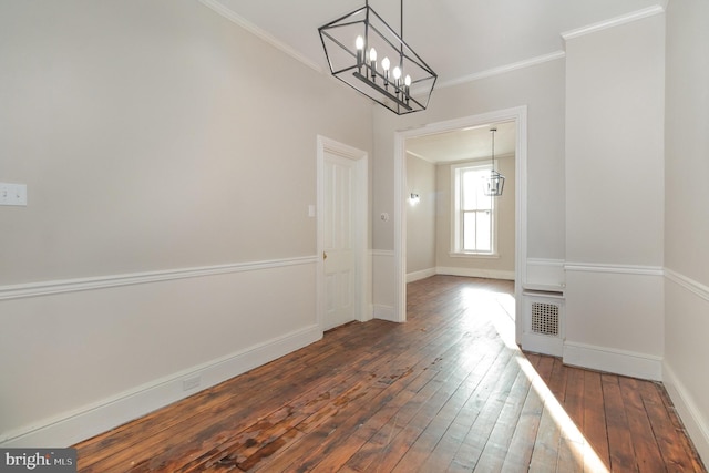 unfurnished dining area with a notable chandelier, dark hardwood / wood-style floors, and ornamental molding