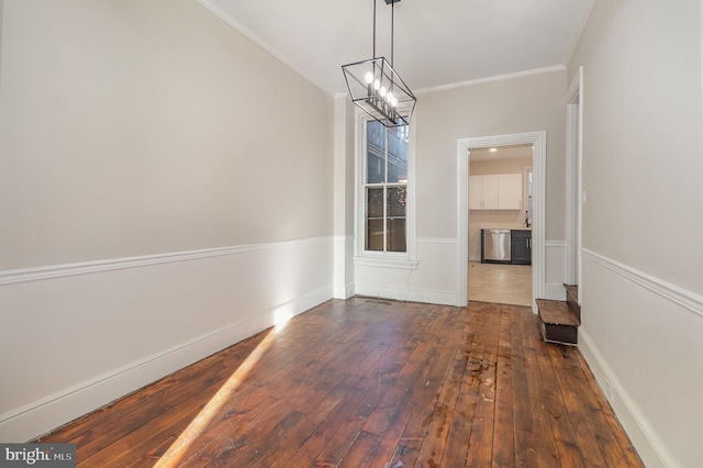 unfurnished dining area with a notable chandelier, dark hardwood / wood-style floors, and crown molding