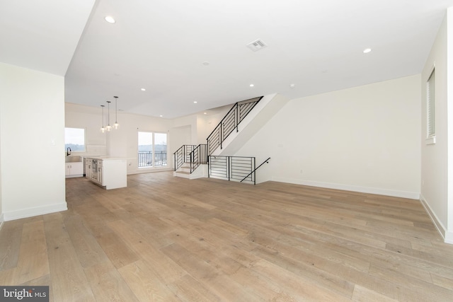 unfurnished living room featuring light hardwood / wood-style floors and sink