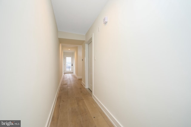 hallway with light hardwood / wood-style flooring