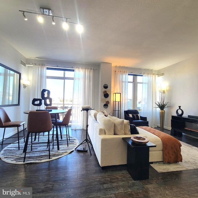 living room with dark wood-type flooring and a textured ceiling