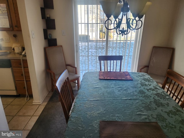 dining space featuring light tile patterned flooring and an inviting chandelier