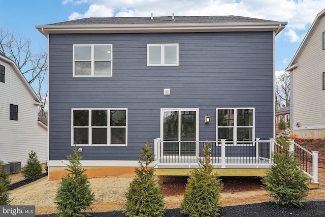 rear view of property featuring central AC and a wooden deck