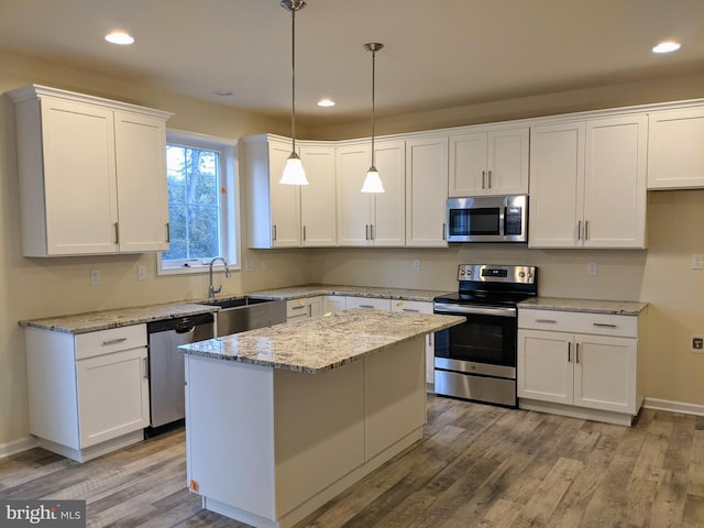 kitchen with a center island, sink, white cabinets, and appliances with stainless steel finishes