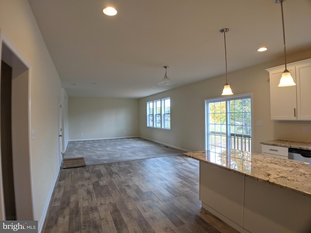 kitchen with dishwasher, hanging light fixtures, light stone counters, dark hardwood / wood-style flooring, and white cabinets