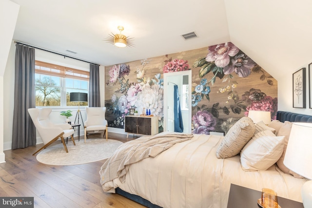 bedroom with hardwood / wood-style flooring and lofted ceiling