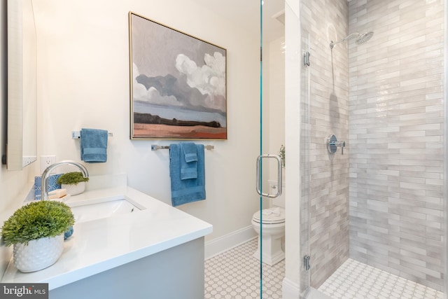 bathroom with tile patterned floors, vanity, toilet, and a shower with shower door