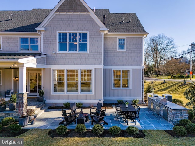 rear view of house featuring a yard, an outdoor kitchen, cooling unit, and a patio area