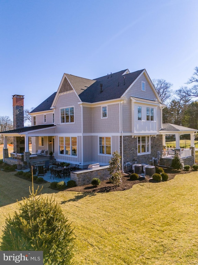 back of property with a lawn, a patio area, and cooling unit