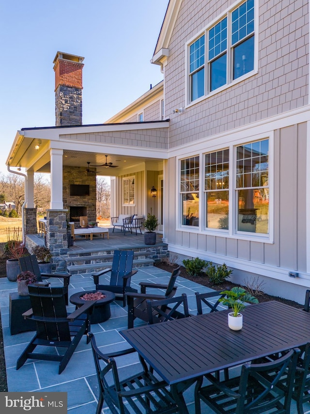 view of patio with ceiling fan and exterior fireplace