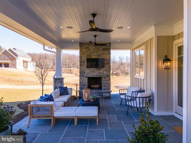 view of patio with an outdoor living space with a fireplace and ceiling fan