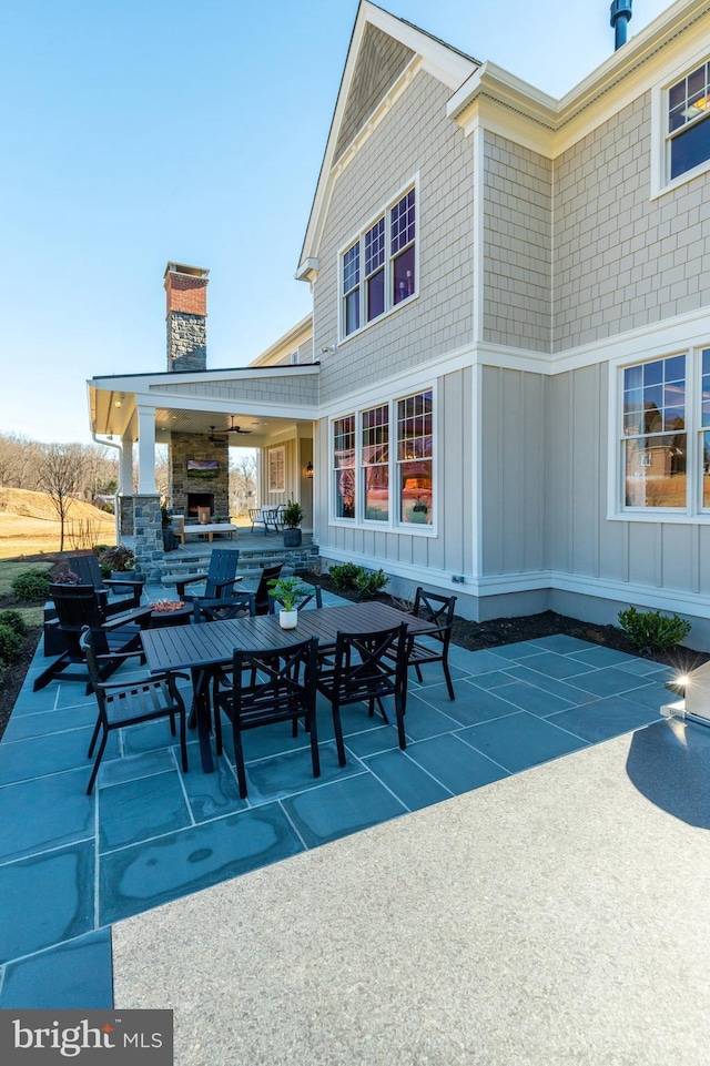 view of patio with ceiling fan and an outdoor fireplace