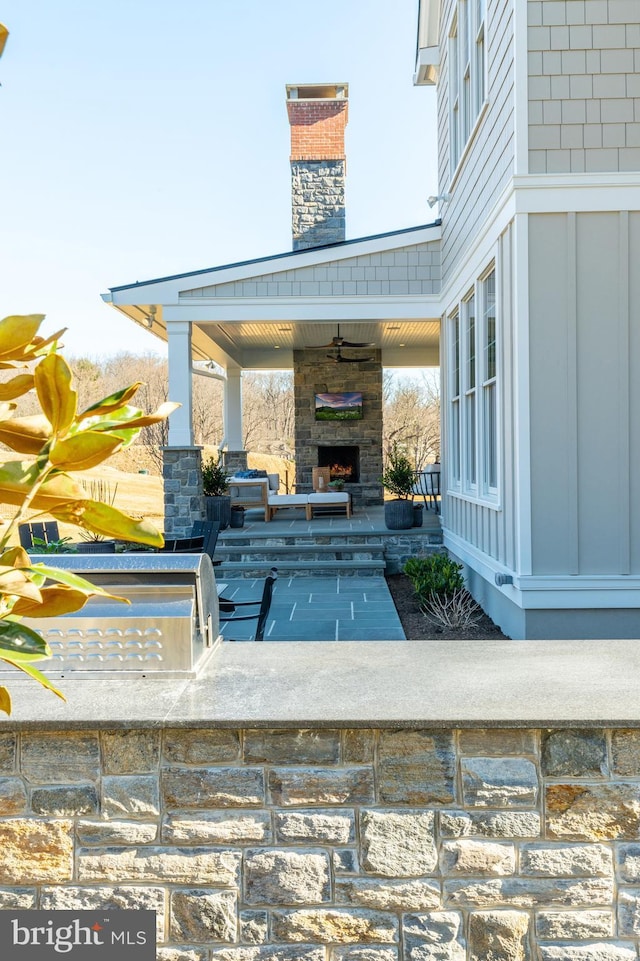 view of patio / terrace featuring an outdoor stone fireplace