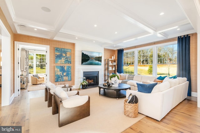 living room with beamed ceiling, light hardwood / wood-style floors, a fireplace, and coffered ceiling