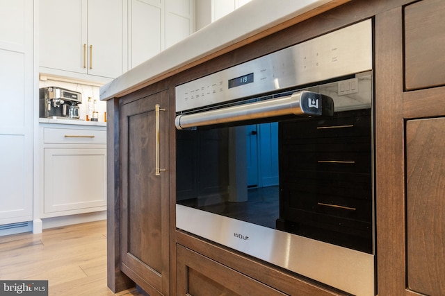 kitchen with light hardwood / wood-style flooring and white cabinets