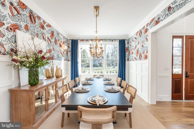 dining room with light hardwood / wood-style floors, an inviting chandelier, and crown molding