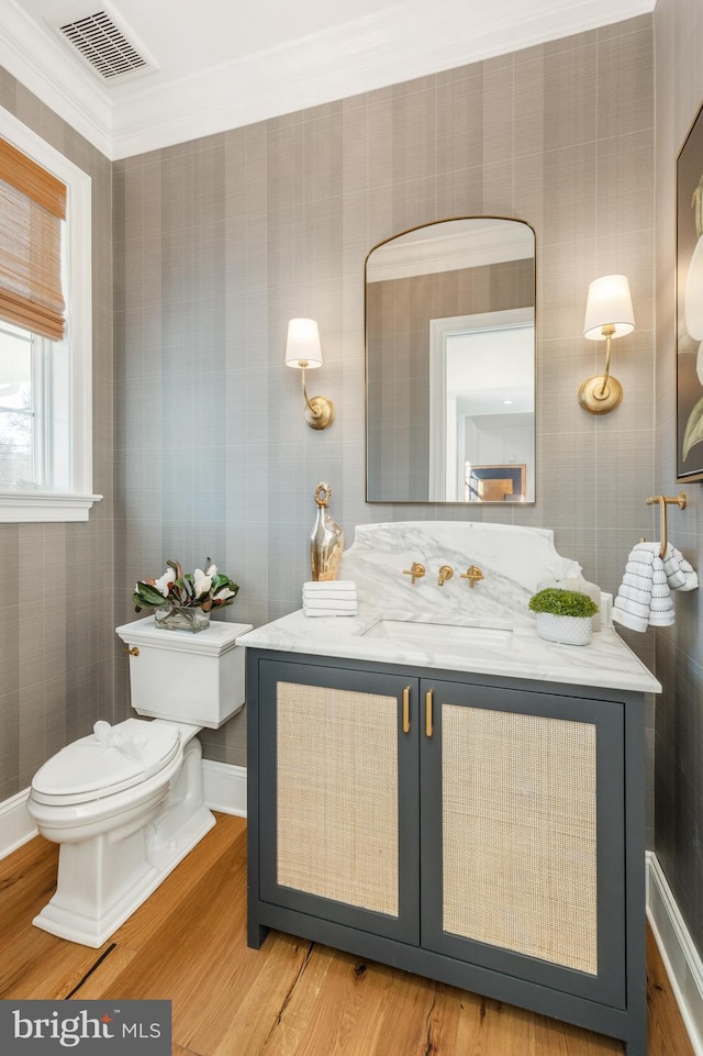 bathroom featuring crown molding, toilet, vanity, and hardwood / wood-style flooring