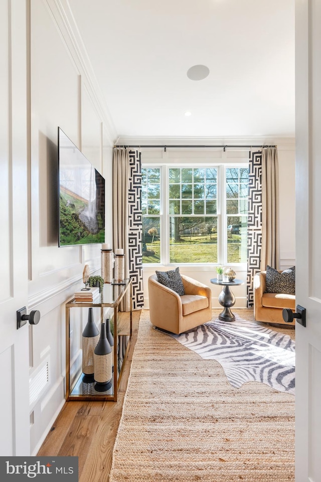 living room with hardwood / wood-style flooring and ornamental molding